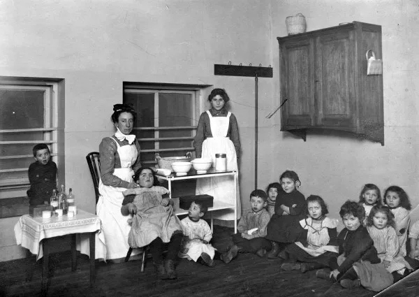Afbeelding uit: 1913. Twee juffen en enkele kinderen van de bewaarschool.