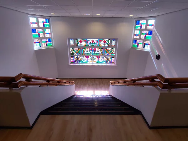 Afbeelding uit: september 2023. Trappenhuis met glas-in-loodramen van Jacoba van Heemskerck. Het thema van de abstract ontworpen ramen was zeilboten.