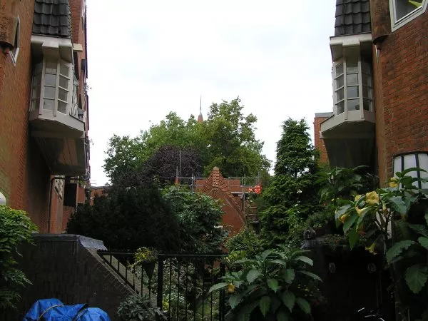 Afbeelding uit: september 2011. Binnenterrein, met tussen het groen het dak van het verenigingsgebouw.