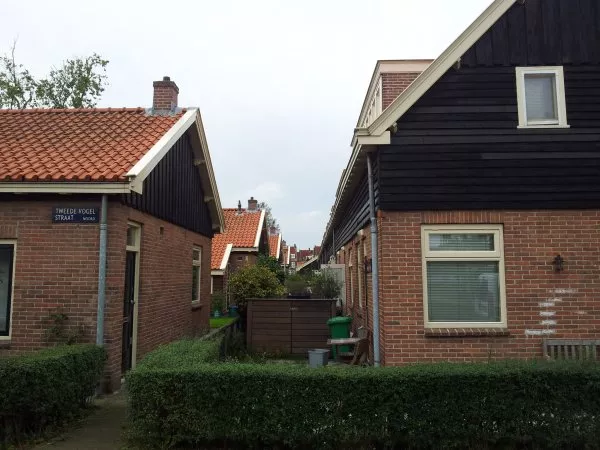 Afbeelding uit: september 2011. Blik op de bescheiden achtertuinen van de huizen aan de Lange Vogelstraat. Gezien richting Meeuwenlaan. Links is Tweede Vogelstraat 15, rechts is Vogelplein 2.