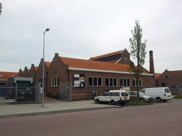 Afbeelding uit: september 2011. Toen de fabriek in gebruik was, was de straat op de voorgrond het Hamerkanaal en stonden de loodsen met hun kopse kant (links) aan het Johan van Hasseltkanaal.
