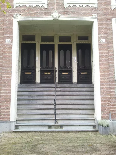Afbeelding uit: november 2013. Het middelste portiek. De deuren zijn vermoedelijk origineel. Plafond en muren hebben sierstucwerk.