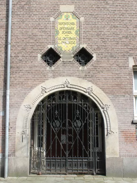 Afbeelding uit: maart 2017. Portaal. Het tegeltableau met de naam van de school is gemaakt door de Amsterdamse plateelbakkerij 'De Distel'. In 2019 is het hersteld.