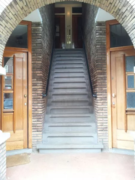 Afbeelding uit: juni 2014. Sloestraat. Het hele blok heeft dit soort portieken, met tussen de ingangen van de benedenwoningen een steektrap naar de deuren van de bovenwoningen.