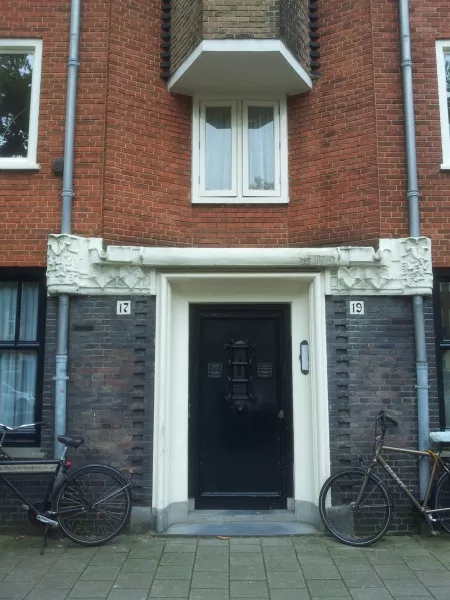 Afbeelding uit: augustus 2014. Joh.M. Coenenstraat. Gedecoreerde betonnen vergaarbakken voor regenwater boven de deur.
