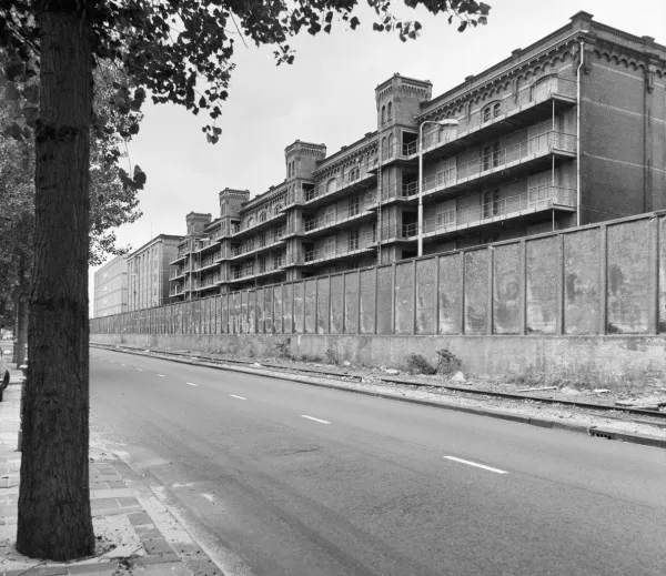 Afbeelding uit: september 1979. Zuidzijde, nog met galerijen tussen de liftschachten. De pakhuizen waren destijds afgescheiden van de straat door een betonnen muur.