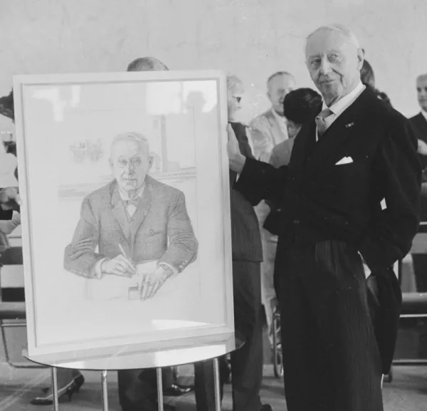 Afbeelding uit: juli 1964. Dudok naast een portret dat hem op zijn verjaardag in Hilversum werd aangeboden.