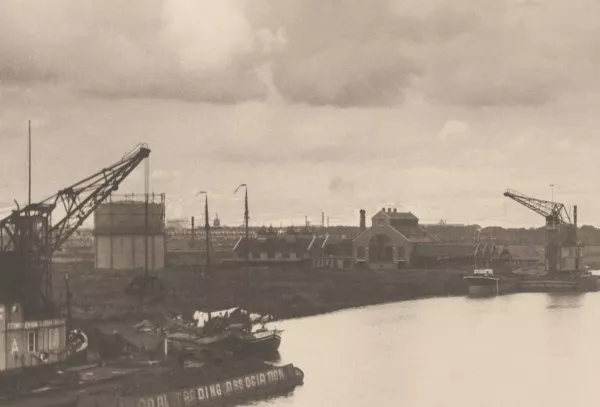 Afbeelding uit: 1916. Gezien in noordwestelijke richting; op de voorgrond het Johan van Hasseltkanaal. Bij de gasfabriek worden kolen gelost. Links de gashouder.