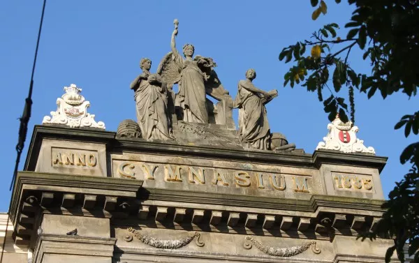 Afbeelding uit: september 2015. Links een wapenschild met koggeschip (het oude stadssymbool), in het midden de 'Triomf der Wetenschap', en rechts een schild met de drie Andreaskruizen.