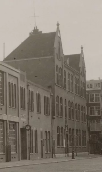 Afbeelding uit: circa 1925. Hier zijn de oorspronkelijke kappen nog aanwezig. In het gebouw links huisde de stadsdrukkerij.
Bron afbeelding: SAA, bestand 010003013261.