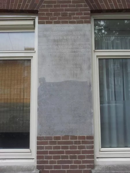 Afbeelding uit: oktober 2015. De plaquette (Frederik Hendrikstraat) memoreert de vergadering waarin besloten werd tot de bouw van de huizen. Vermeld zijn de namen van leden van de Commissie van Toezicht, het Bestuur, en de Raad van Vertegenwoordiging.