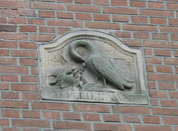 Afbeelding uit: december 2015. De gevelsteen boven de ingang naar het binnenterrein. Een pelikaan voedt zijn of haar jongen met het eigen bloed, een symbool van liefde en opoffering.