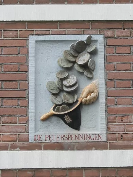 Afbeelding uit: juli 2016. De steen in de gevel aan de Spiegelstraat werd in 2003 aangebracht, bij het afscheid van dhr. Peters, een bestuurder van Stadsherstel.