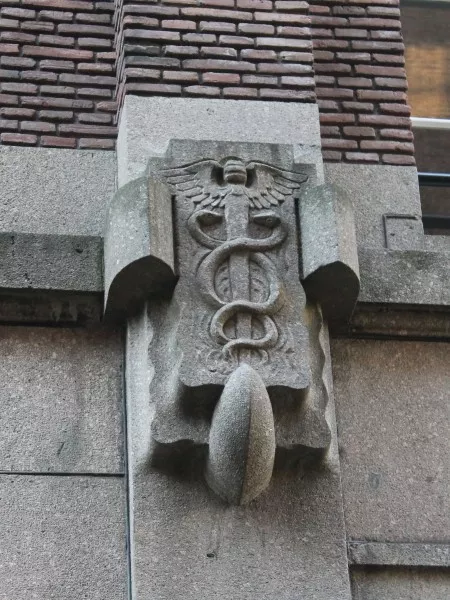 Afbeelding uit: oktober 2016. Gevel Driekoningenstraat. Gevleugelde staf met twee slangen: symbool van de handel.