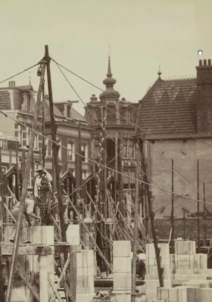 Afbeelding uit: 1898. Achter de bouwplaats van het hoofdpostkantoor is het hoekpand met torentje te zien.
Bron afbeelding: SAA, bestand ANWO00125000001.