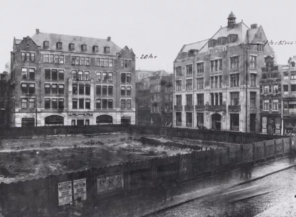 Afbeelding uit: circa 1918. Links Dam 3-7, rechts het Polmanshuis (de voorganger van het huidige Krasnapolsky).
Bron afbeelding: SAA, bestand 010009000061.