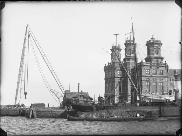 Afbeelding uit: 1891. De kop van de kade, met links de zware mastbok (walbok) en rechts het gebouw voor Algemene Dienst.