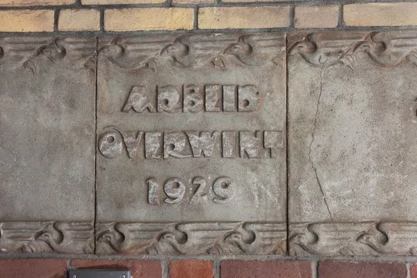 Afbeelding uit: april 2017. Steen met de tekst "Arbeid overwint 1929", in het portiek.