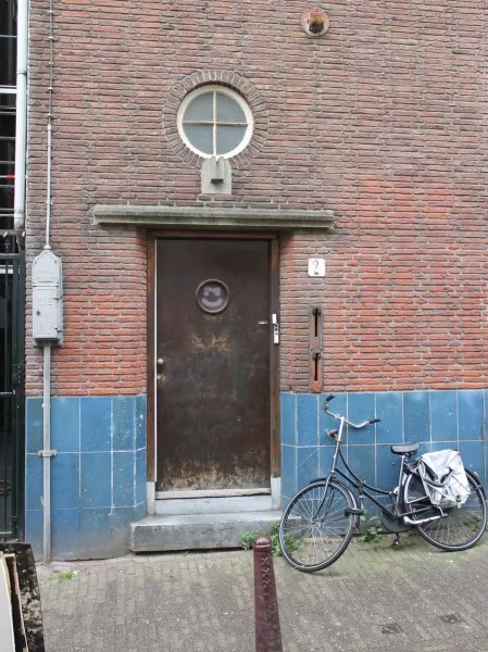 Afbeelding uit: mei 2017. De ingang van de woningen, in de Binnen Oranjestraat. Rechts van de deur twee keramieken gleuven voor de post.