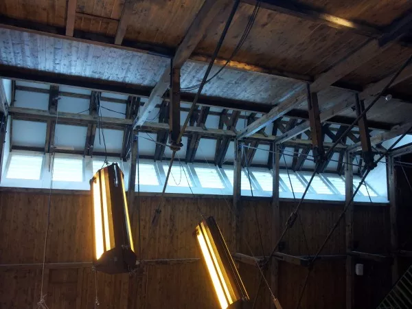 Afbeelding uit: juni 2017. De kap, met een Polonceau-constructie, met houten en stalen balken en spanten. Het licht valt door wat ooit de ventilatiekap was.