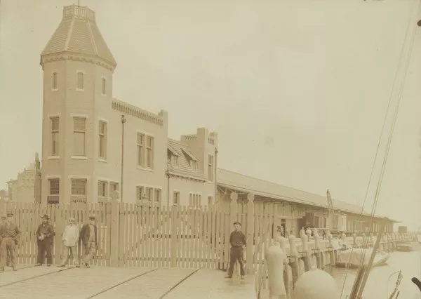 Afbeelding uit: circa 1907. Het kantoorgebouw, en daarachter de lange loods.
Bron afbeelding: SAA, bestand ABBB00008000017.