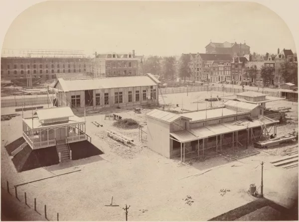 Afbeelding uit: 1869. Op de achtergrond zijn Frederiksplein 36-38 in aanbouw. Op de voorgrond tijdelijke constructies voor een tentoonstelling in het Paleis voor Volksvlijt.
Bron afbeelding: SAA, bestand B00000029311.