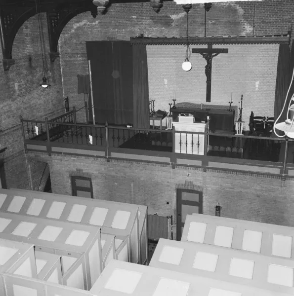Afbeelding uit: september 1964. Kerkzaal, met hokjes voor de gedetineerden, die hier geen contact met elkaar mochten hebben.