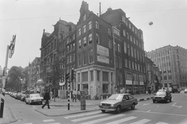 Afbeelding uit: juli 1987. Links de Voorburgwal, rechts de Paleisstraat. Het hoge gebouw in de Paleisstraat is de uitbreiding van 1920.
