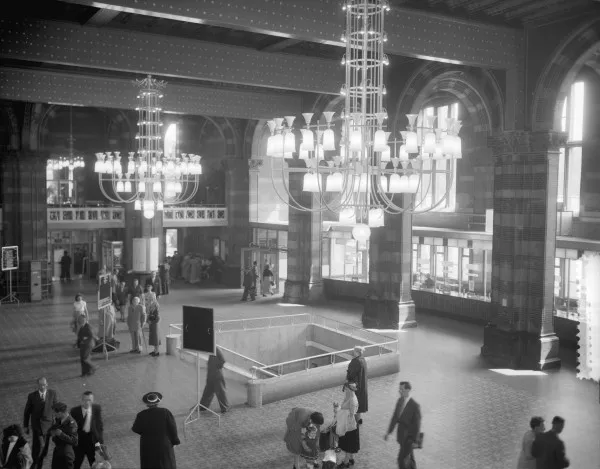 Afbeelding uit: mei 1956. De centrale hal, met een voetgangerstunnel naar het Stationsplein. Die was destijds nodig om het autoverkeer op het plein te ontlopen.
