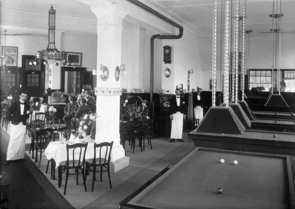 Afbeelding uit: 1914. Interieur van café-restaurant De Arend, met vier biljarts. Het opende in november 1914 de deuren op de hoek met het park.
