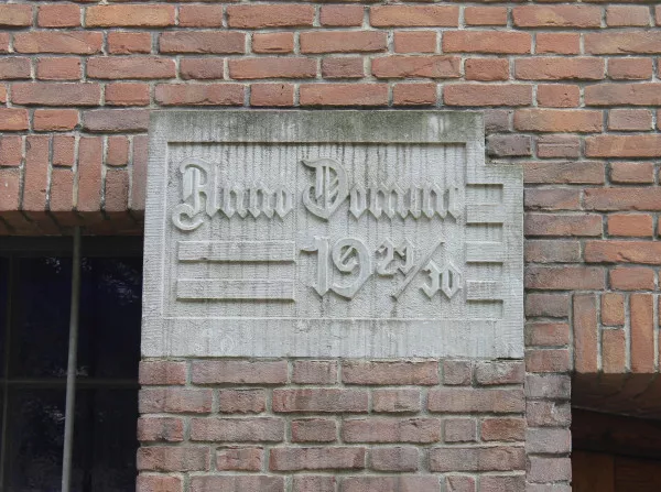 Afbeelding uit: juni 2018. Steen met de tekst "Anno Domini 1929/30", rechts van de ingang.