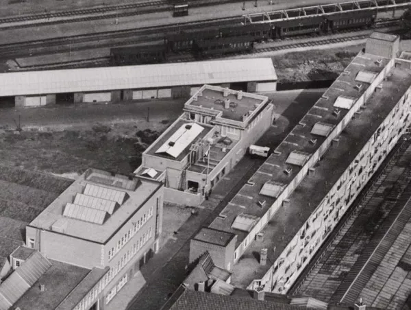 Afbeelding uit: september 1938. Uitsnede van een luchtfoto. Het vrachtwagentje staat voor een van de ijsluiken. Linksonder een gedeelte van drukkerij Paragon, rechts een woonblok van architect Kruyswijk.
Bron afbeelding: SAA, bestand A04139001068.