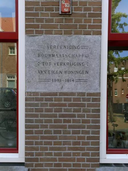 Afbeelding uit: juli 2018. Gedenksteen in de gevel van de Lampongstraat. "Vereeniging Bouwmaatschappij tot Verkrijging van Eigen Woningen 1913-1914".