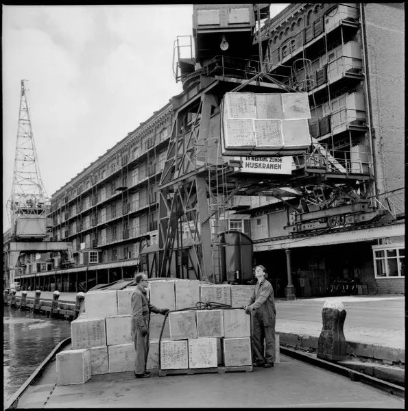 Afbeelding uit: juli 1962. Voorzijde, met havenkranen. De thee op de voorgrond is voor pakhuis Zondag.