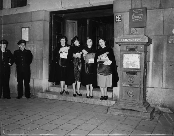 Afbeelding uit: januari 1957. Vrouwelijke postbodes op de drempel van het postkantoor.