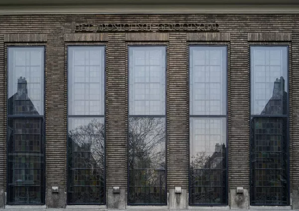 Afbeelding uit: november 2018. Vijf van de hoge glas-in-loodramen, met daarboven de naam van het kerkgenootschap.