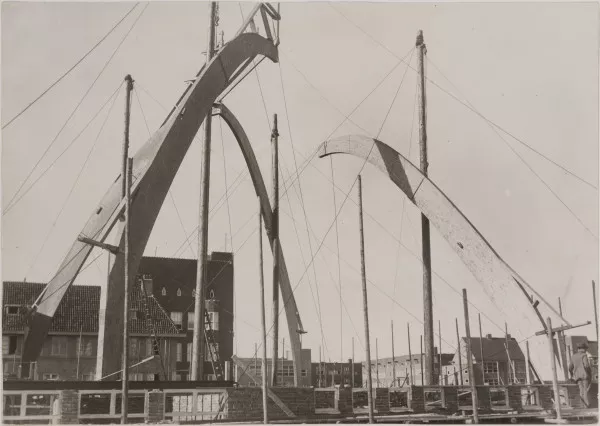 Afbeelding uit: september 1928. In aanbouw. De vier houten spanten die het dak moeten dragen worden geplaatst.
Bron afbeelding: SAA, bestand OSIM00004001979.
