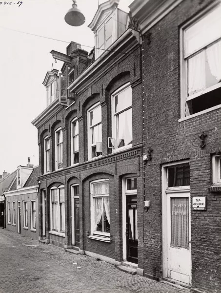 Afbeelding uit: circa 1939. Rechts de ingang van de tapperij bij het café op Middenweg 73.
Bron afbeelding: SAA, bestand 010009011574.