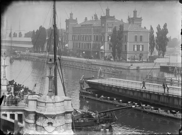 Afbeelding uit: mei 1895. Op de voorgrond de geopende draaibrug naar Kattenburg.
Bron afbeelding: SAA, bestand 010019000773.