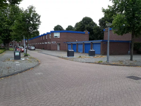 Afbeelding uit: augustus 2019. Johannes Jelgerhuishof. De deuren van de garageboxen zijn in dezelfde kleur blauw geschilderd als de boeiborden.
