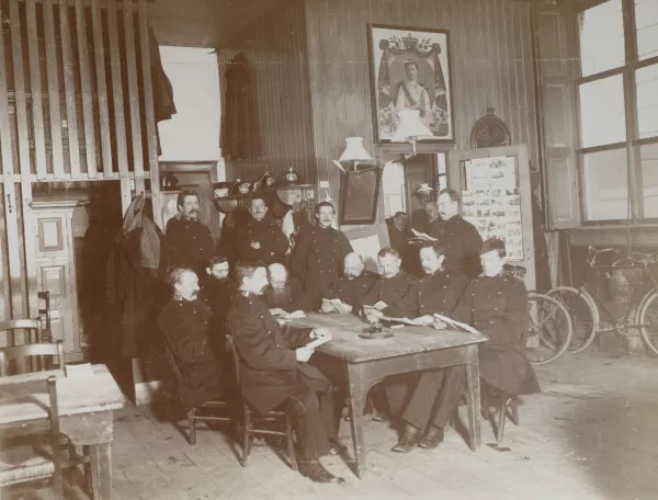 Afbeelding uit: circa 1900. Agenten in de wachtkamer van het hoofdbureau aan de Spinhuissteeg.
Bron afbeelding: SAA, bestand HDAB00001000002_002.