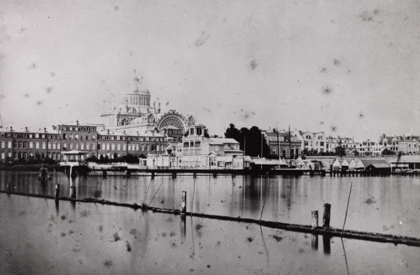 Afbeelding uit: circa 1870. De Amsteljachthaven. Links de achterkant van de huizen  aan het Oosteinde; daarachter het Paleis voor Volksvlijt.
Bron afbeelding: SAA, bestand OSIM00004000687.