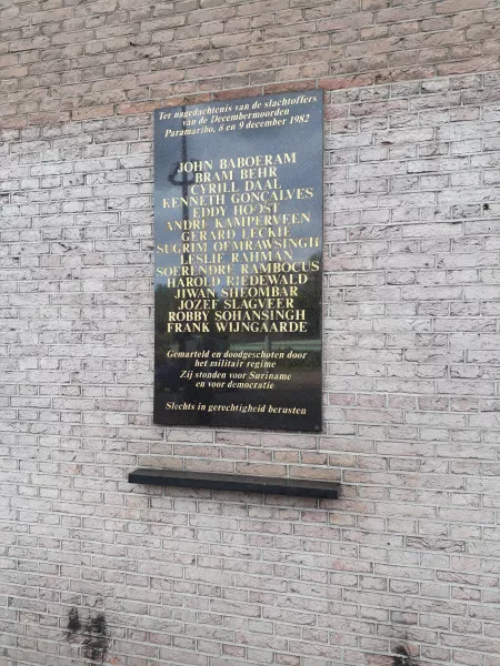 Afbeelding uit: september 2019. In de zijgevel is een plaquette aangebracht ter nagedachtenis van de slachtoffers van de Decembermoorden in Suriname in 1982.