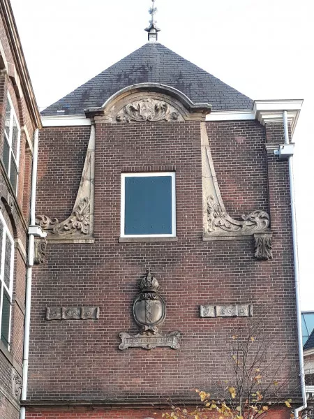 Afbeelding uit: oktober 2019. Een ingemetselde halsgevel uit 1719. Daaronder 'Anno 1665' en een cartouche met "T REEF FE NEER HUIS": het raffineerhuis, een verdwenen pand aan de Palmgracht waar salpeter werd geraffineerd voor de productie van buskruit.