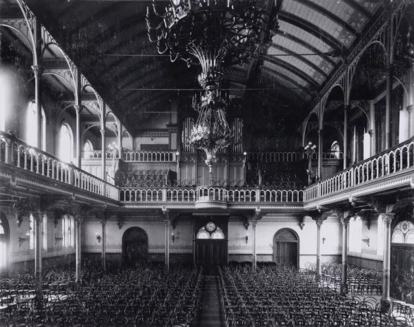 Afbeelding uit: circa 1900. Interieur, gezien naar de hoofdingang.
Bron afbeelding: SAA, bestand OSIM00008003391.