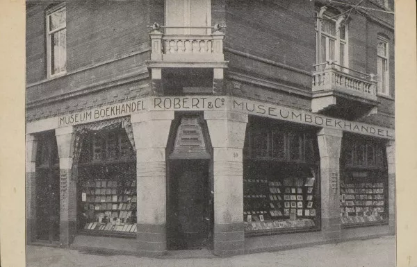 Afbeelding uit: circa 1926. Prentbriefkaart van de hoek niet lang na de verbouwing tot winkel, voor museumboekhandel Robert & Co., die hier vanaf 1925 gevestigd was.
Bron afbeelding: SAA, bestand PBKD00045000002.
