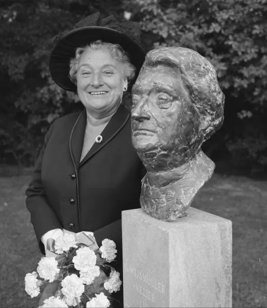 Afbeelding uit: september 1965. Truus Wijsmuller naast de buste met haar portret, bij het Beatrixoord in het Oosterpark. Wijsmuller was lang bestuurslid van het herstellingsoord. De buste staat nu op het Bachplein. (uitsnede)