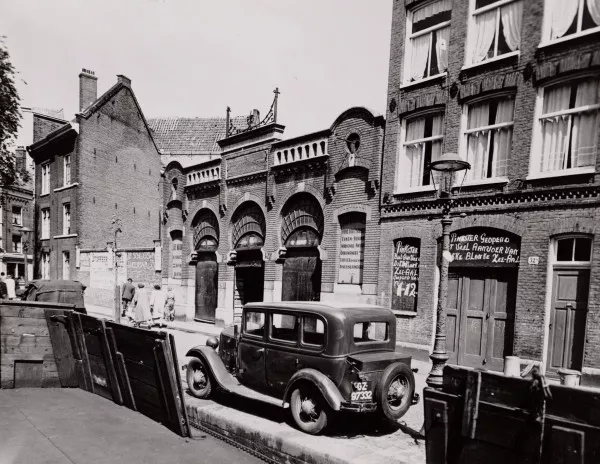 Afbeelding uit: juli 1953. In 1953 was het gebouw in gebruik bij fijnhouthandel De Kroon.
Bron afbeelding: SAA, bestand 010009007586.
