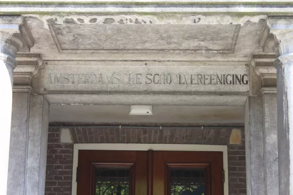 Afbeelding uit: april 2020. "Amsterdamsche Schoolvereeniging", staat er boven de hoofdingang.