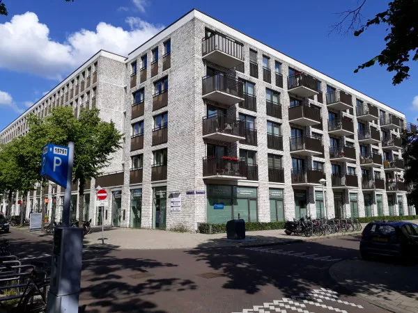 Afbeelding uit: juni 2020. Het nieuwe gebouw, met als werktitel Blok M. Het telt 84 woningen voor ouderen. In het gebouw kwam ook een gezondheidscentrum. Ontworpen door Studioninedots voor Rochdale en Habion, opgeleverd in 2015.